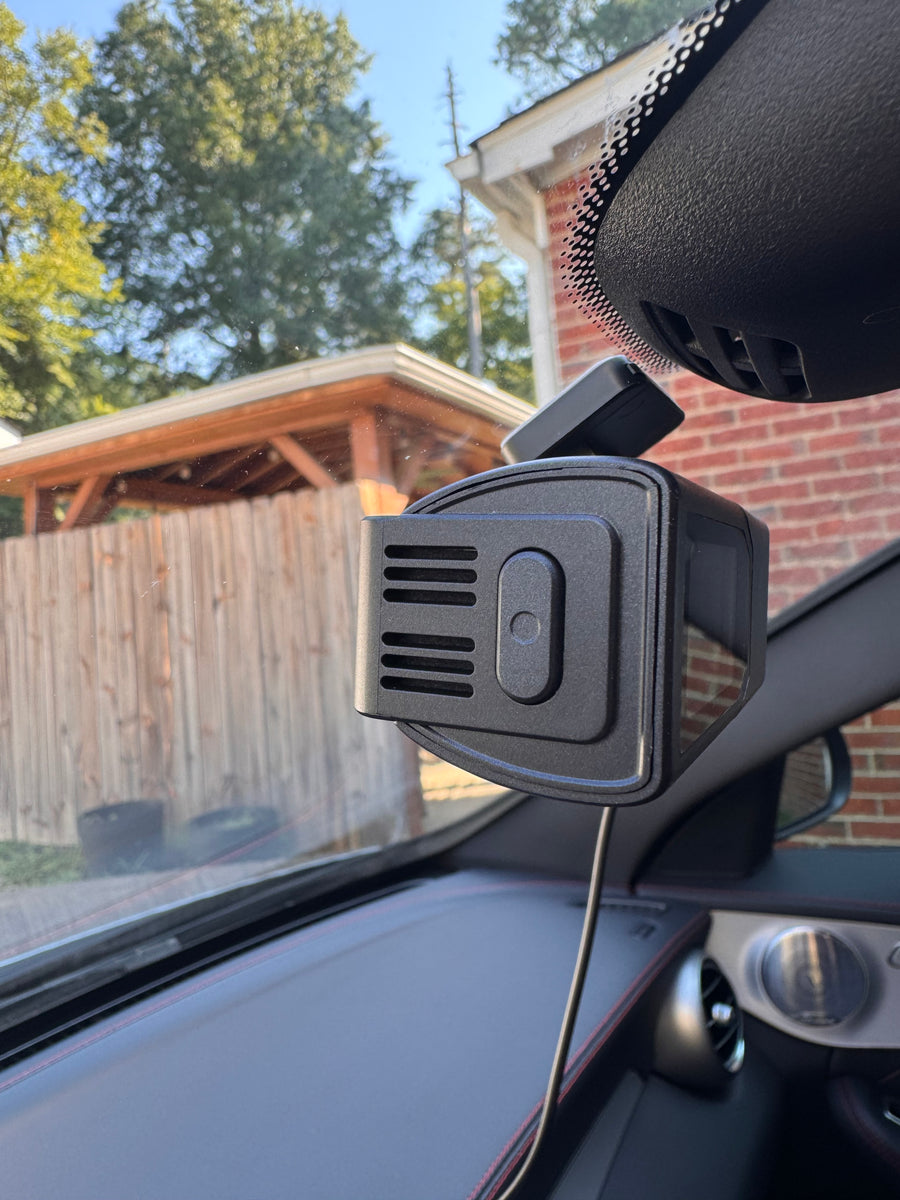 Close-up of the Plainview One behind the rearview mirror, showing the clip-save button on its side