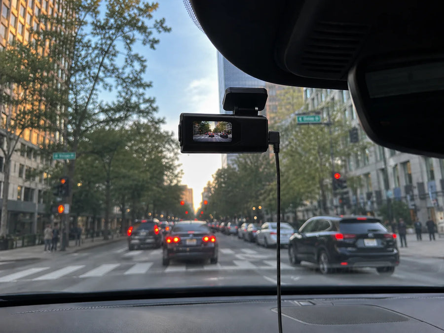 Plainview One mounted behind the rearview mirror on a daytime city street